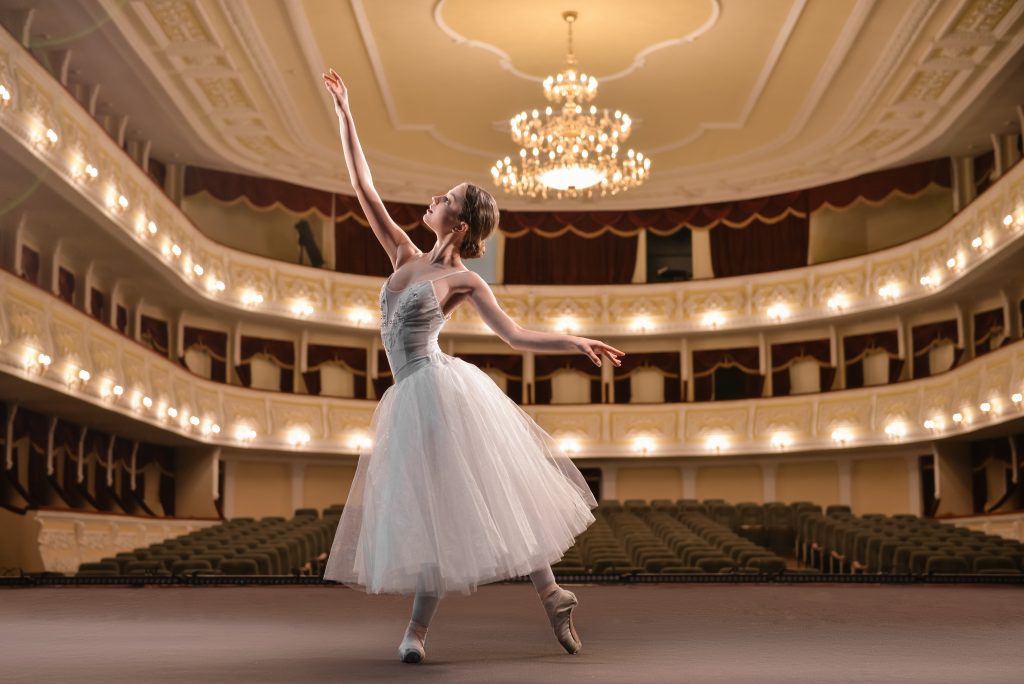 Beautiful young ballerina dancing in theatre